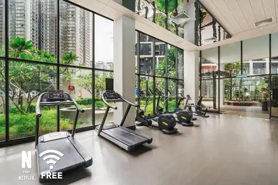 a gym with cardio equipment in a building with windows at OOAK 2BR - Mont Kiara Garden international school in Kuala Lumpur
