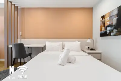 a bedroom with a white bed and a desk at OOAK 2BR - Mont Kiara Garden international school in Kuala Lumpur