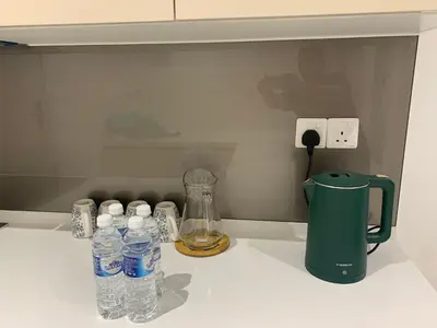 a counter with bottles of water and a blender at Quill Residences Klcc By AB in Kuala Lumpur