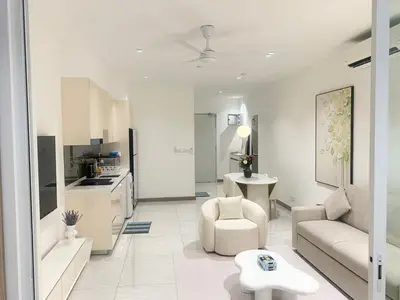 a white living room with a couch and a table at Quill Residences Klcc By AB in Kuala Lumpur