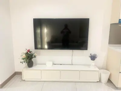 a living room with a tv on a white wall at Quill Residences Klcc By AB in Kuala Lumpur