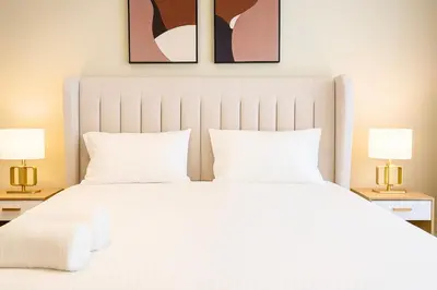 a bedroom with a large white bed with two lamps at Quill Residences Klcc By AB in Kuala Lumpur