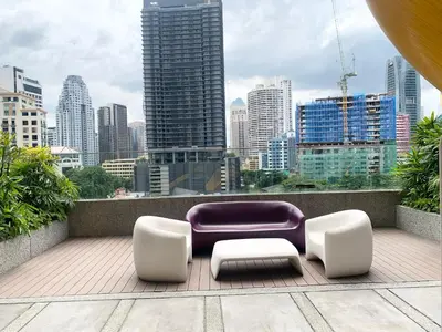a purple couch and two white chairs and a city at Quill Residences Klcc By AB in Kuala Lumpur