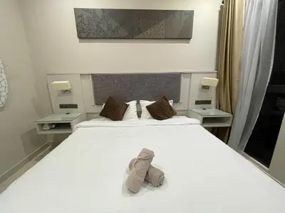 a bed with two stuffed animals sitting on it at Weekend House Trion in Kuala Lumpur