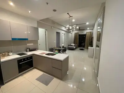 a kitchen with a counter and a living room at Weekend House Trion in Kuala Lumpur