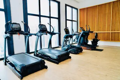 a gym with several exercise bikes in a room with windows at Luxury Suites Lucentia Residence KLCC at BBCC in Kuala Lumpur