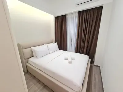 a bedroom with a white bed with a candle on it at Agile Residensi Service Apartment Kuala lumpur in Kuala Lumpur