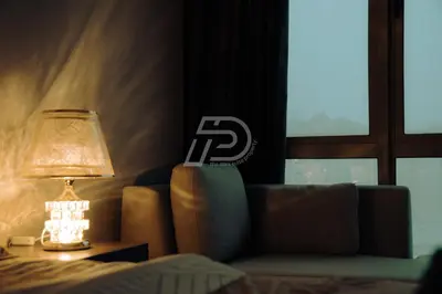 a bedroom with a couch and a lamp and a window at Dorsett Hartamas KL, Bathtub Smart TV & WiFi in Kuala Lumpur