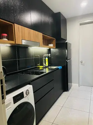 a kitchen with black cabinets and a washing machine at Axon Suites Bukit Bintang near KLCC by Unitopia in Kuala Lumpur
