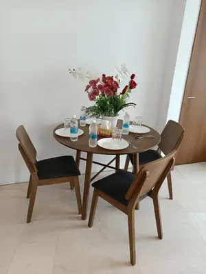 a wooden table with chairs and a vase of flowers at KLCC Sky Villa Suites Vortex in Kuala Lumpur