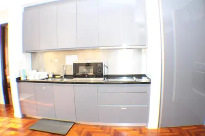 a kitchen with white cabinets and a microwave at KLCC Sky Villa Suites The Mews in Kuala Lumpur