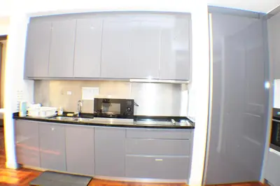 a kitchen with white cabinets and a microwave at KLCC Sky Villa Suites The Mews in Kuala Lumpur