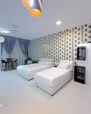 two white beds in a room with a wall at Regalia Suites Kuala Lumpur by Cozyvista Suites in Kuala Lumpur