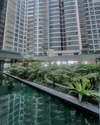 a pool of water with palm trees and buildings at Regalia Suites Kuala Lumpur by Cozyvista Suites in Kuala Lumpur