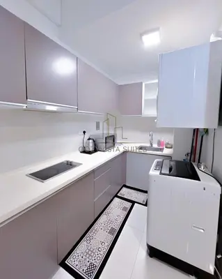 a white kitchen with a sink and a refrigerator at Regalia Suites Kuala Lumpur by Cozyvista Suites in Kuala Lumpur