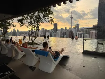 a group of people sitting in chairs on a rooftop pool at Axon Residensi Bukit Bintang in Kuala Lumpur