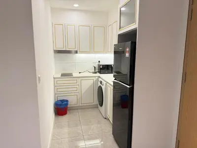 a kitchen with white cabinets and a black refrigerator at Axon Residensi Bukit Bintang in Kuala Lumpur