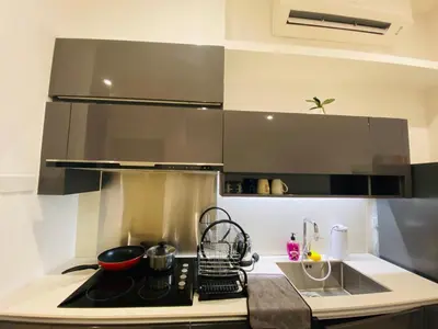 a kitchen with a stove top oven next to a sink at Lucentia Residences Bukit Bintang KLCC By LUZBNB in Kuala Lumpur