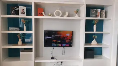 a room with a tv in a wall with shelves at The Platinum KLCC By Aura Suites in Kuala Lumpur