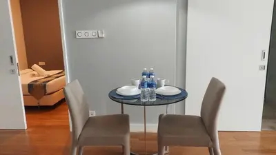 a dining room table with two chairs and a table with drinks at The Platinum KLCC By Aura Suites in Kuala Lumpur