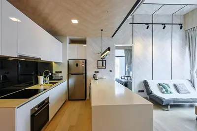 a kitchen with white countertops and a couch in a room at Star Residences By Minos Homestay in Kuala Lumpur