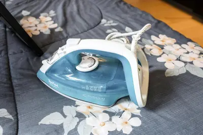 a blue and white phone sitting on a bed with flowers at Star Residences By Minos Homestay in Kuala Lumpur