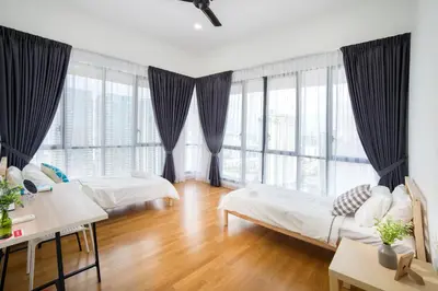 a living room with two beds and large windows at Karaoke Party Penthouse at KL Gateway by Cobnb in Kuala Lumpur