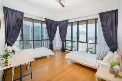 a large room with two beds and windows at Karaoke Party Penthouse at KL Gateway by Cobnb in Kuala Lumpur