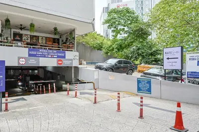 a parking lot with orange cones in front of a tunnel at KAĨTE Suites at Wisma Cosway Sky Bridge to Pavilion KL in Kuala Lumpur
