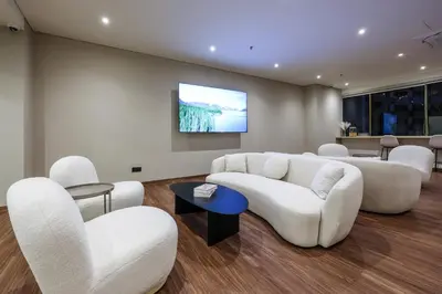 a living room with white furniture and a flat screen tv at KAĨTE Suites at Wisma Cosway Sky Bridge to Pavilion KL in Kuala Lumpur