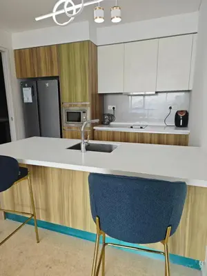 a kitchen with a sink and a counter with two chairs at KL29 3BR4B Jalan Ampang Near KLCC in Kuala Lumpur