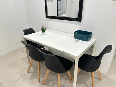 a white table with black chairs and a mirror at Taragon Luxury Suites Bukit Bintang,Kuala Lumpur in Kuala Lumpur