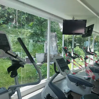 a gym with three exercise bikes and a flat screen tv at Damas Plaza-Hartamas in Kuala Lumpur