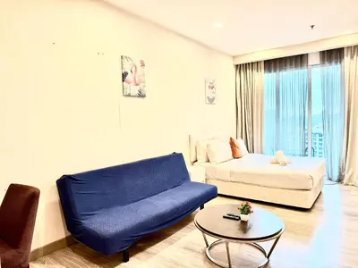 a living room with a blue couch and a table at Crystal Suites at Ramad KLCC in Kuala Lumpur