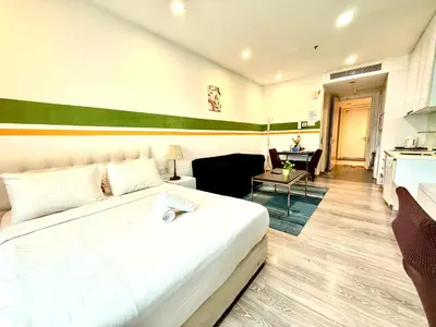 a bedroom with a large white bed and a kitchen at Crystal Suites at Ramad KLCC in Kuala Lumpur