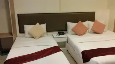 two beds in a hotel room with pillows at SohoTown Hotel in Kuala Lumpur