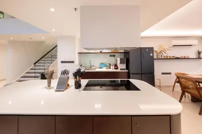 a kitchen with a white counter top and a staircase at La Gente x Novo Ampang 3R3B Duplex Penthouse in Kuala Lumpur