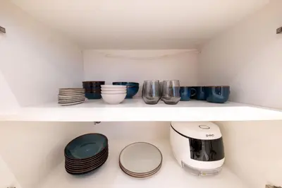 a shelf with plates and cups and a toaster at La Gente x Novo Ampang 3R3B Duplex Penthouse in Kuala Lumpur