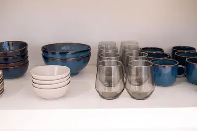 a row of blue and white cups and bowls on a shelf at La Gente x Novo Ampang 3R3B Duplex Penthouse in Kuala Lumpur