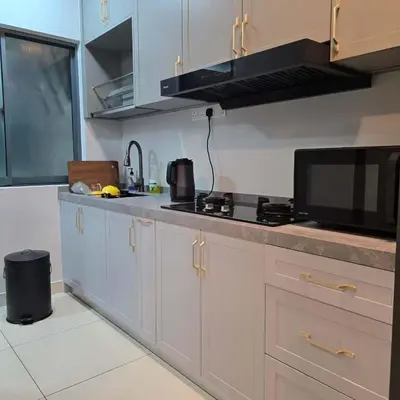a kitchen with white cabinets and a counter top at 3 Tower Ampang Suite in Kuala Lumpur