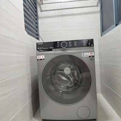 a washing machine in a corner of a room at 3 Tower Ampang Suite in Kuala Lumpur