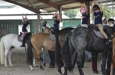 a group of children riding on the backs of horses at 3 Tower Ampang Suite in Kuala Lumpur