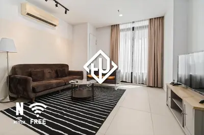a living room with a couch and a tv at Arcoris Mont Kiara 3 min to 163mall 2 Bed in Kuala Lumpur