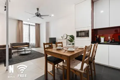 a kitchen and dining room with a wooden table and chairs at Arcoris Mont Kiara 3 min to 163mall 2 Bed in Kuala Lumpur