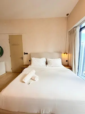 a bedroom with a large white bed with towels on it at Star klcc by AR Accommodation in Kuala Lumpur