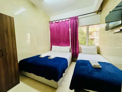 two beds in a small room with purple curtains at Hotel City Bukit Bintang in Kuala Lumpur