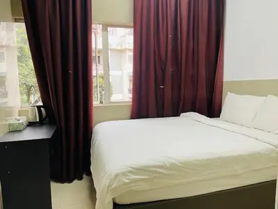 a bedroom with a bed with red curtains and a window at Hotel City Bukit Bintang in Kuala Lumpur