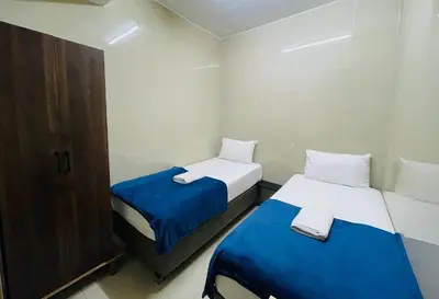 two beds in a small room with blue and white sheets at Hotel City Bukit Bintang in Kuala Lumpur