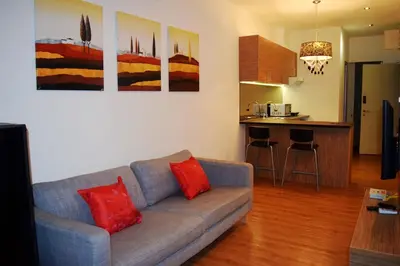 a living room with a couch and a kitchen at Taragon Residences in Kuala Lumpur