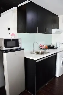 a kitchen with a sink and a microwave at Taragon Residences in Kuala Lumpur